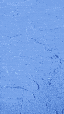 a person is painting a blue wall with white paint