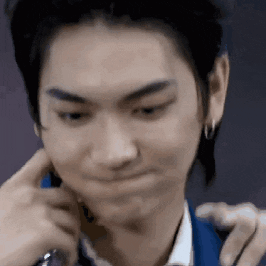a close up of a man making a funny face while talking on a cell phone