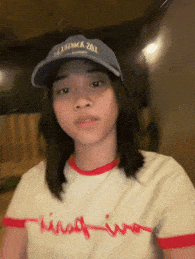 a girl wearing a hat and a t-shirt that says ' king iwo ' on it