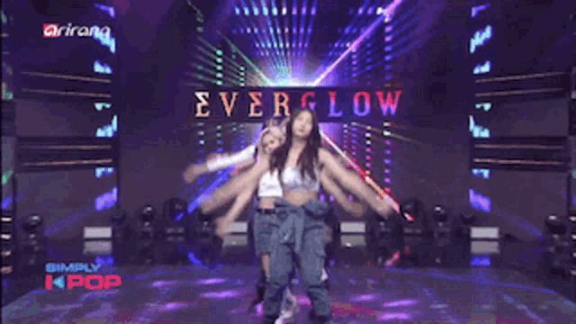 a woman is dancing on a stage in front of a screen that says " simply kpop "