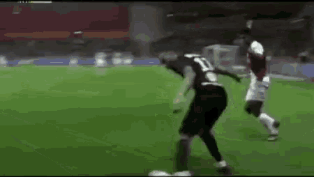 a soccer player is kicking a soccer ball on a field .