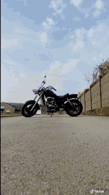a black motorcycle is parked on the side of a road with a tiktok watermark