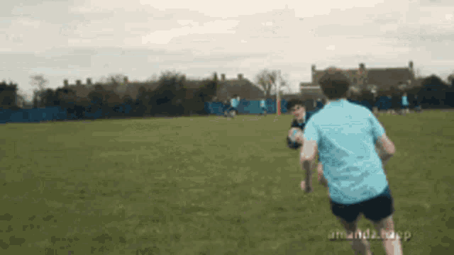 a man in a blue shirt is running on a field
