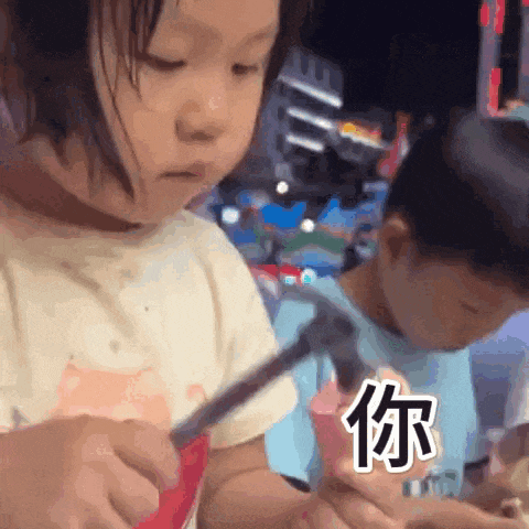 a little girl is holding a pair of scissors while a boy looks on .