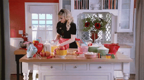 a woman is preparing food in a kitchen with many bowls