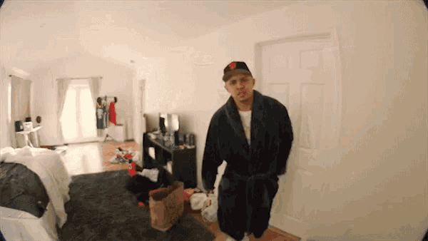a man in a robe and hat is standing in a messy room