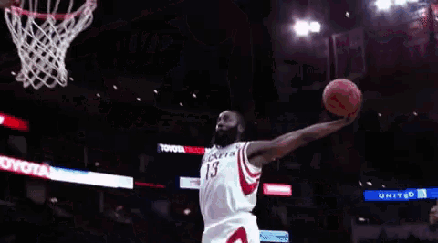 a basketball player is jumping in the air while holding a basketball in front of a toyota sign
