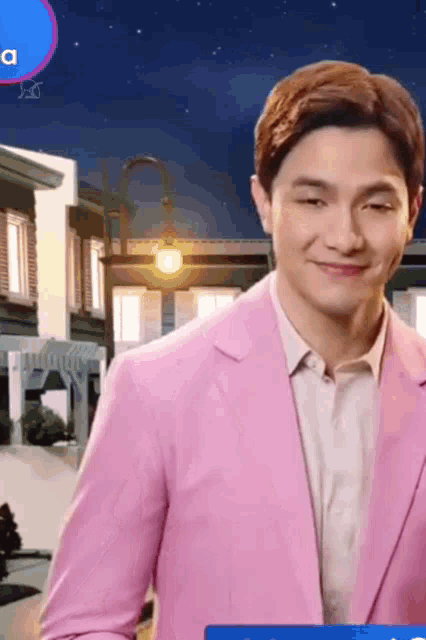a man in a pink suit is smiling in front of a blue sign that says a