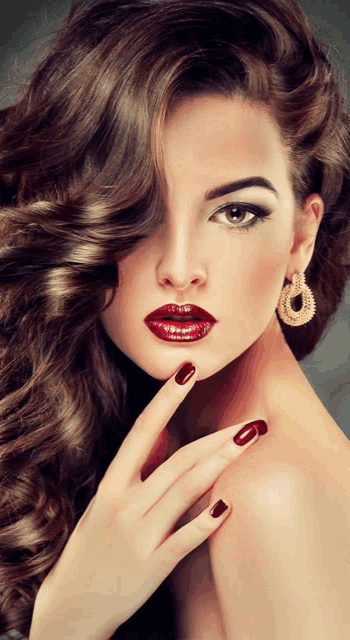 a woman with long brown hair and red nails