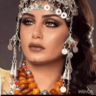 a close up of a woman wearing a necklace and a headpiece that says inshot