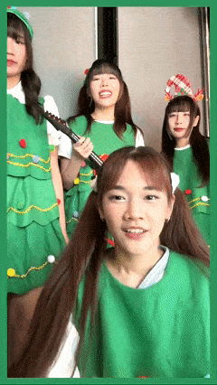 a girl in a green dress holds a guitar