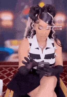 a woman wearing gloves is looking at her phone .