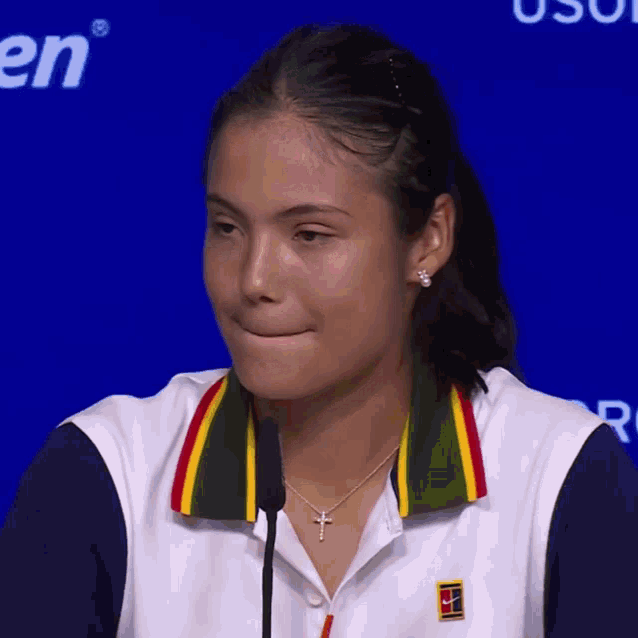 a woman wearing a white shirt with a yellow green and red collar