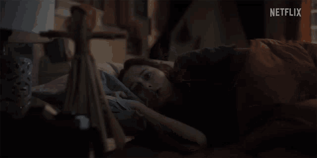 a woman laying in bed with a netflix logo in the background