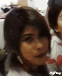 a close up of a woman 's face with the words imgplay on the bottom right