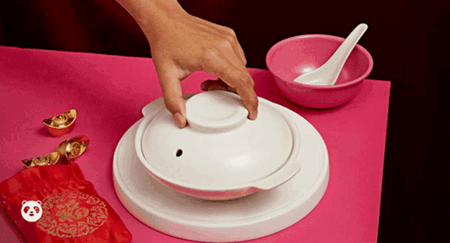 a person is holding the lid of a white bowl