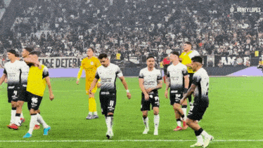 a group of soccer players standing on a field with a banner in the background that says " amor "