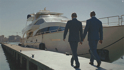 two men in suits are walking towards a yacht that says ' sydney ' on the side