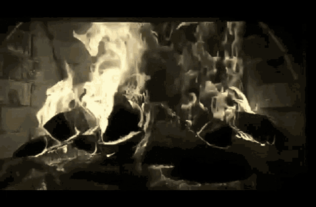 a black and white photo of a fireplace with flames