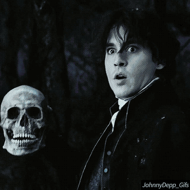a man holding a skull with a surprised look on his face and the words johnnydepp_gifs below him
