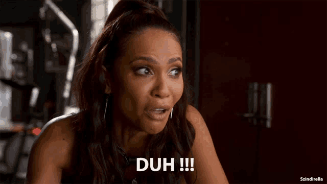 a woman with a surprised look on her face says duh !!!