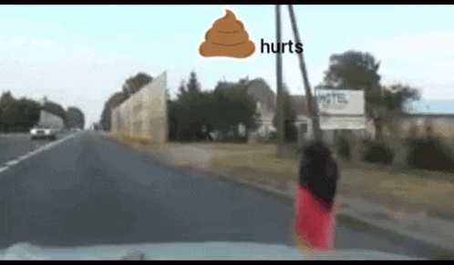 a person standing on the side of a road with a sign that says hurts
