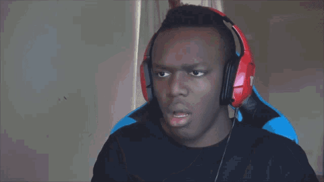 a man wearing red headphones with the letter t on the back