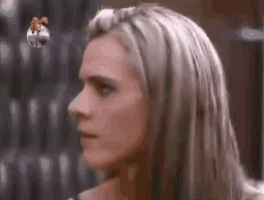 a close up of a woman 's face with long blonde hair and a blurred background .