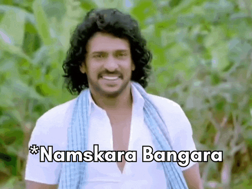 a man with long curly hair is smiling with the words namskara bangara written below him .
