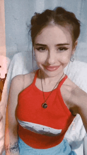 a woman in a red tank top is smiling