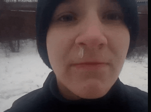 a close up of a woman 's face with a snot coming out of her nose .