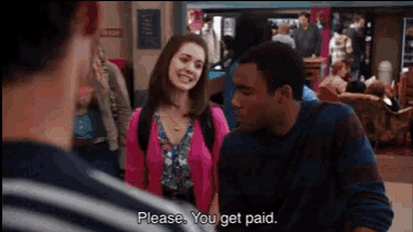 a woman in a pink cardigan is talking to a man in a blue shirt who says please you get paid
