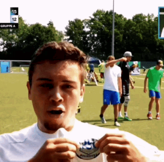 a group of soccer players are on a field and one of them is wearing a white shirt that says gruppe a on it
