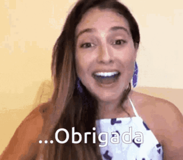 a woman is smiling with the word obrigada written on her face