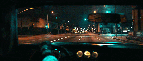 a car is driving down a street at night with a sign that says ' a ' on it
