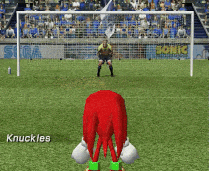 knuckles is playing soccer on a field with a goalie in the background