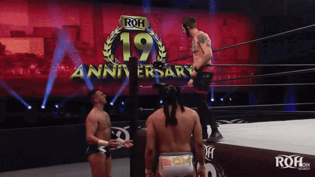 a wrestler stands in front of a sign that says roh 19 anniversary