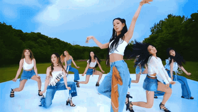 a group of women are dancing in a field
