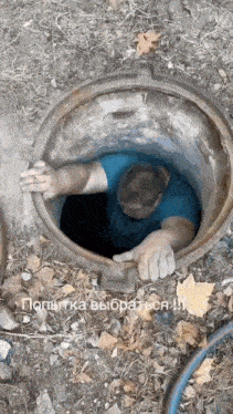 a man is sticking his head out of a manhole cover