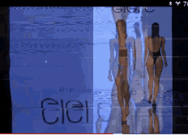 a woman in a bikini walks down a runway in front of a sign that says cleir
