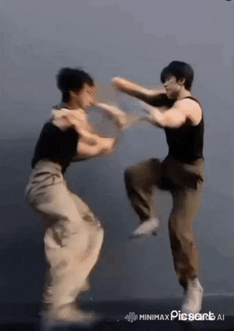 two men are fighting with each other in a room while dancing .