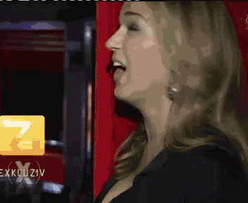 a woman is singing in front of a yellow sign that says ' exklusiv '