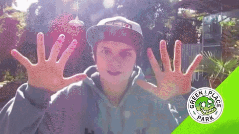 a person wearing a hat and a green hoodie with the words green place park on the bottom