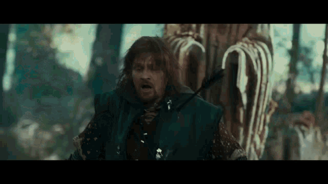 a man with a beard is holding a bow and arrow in his hand .