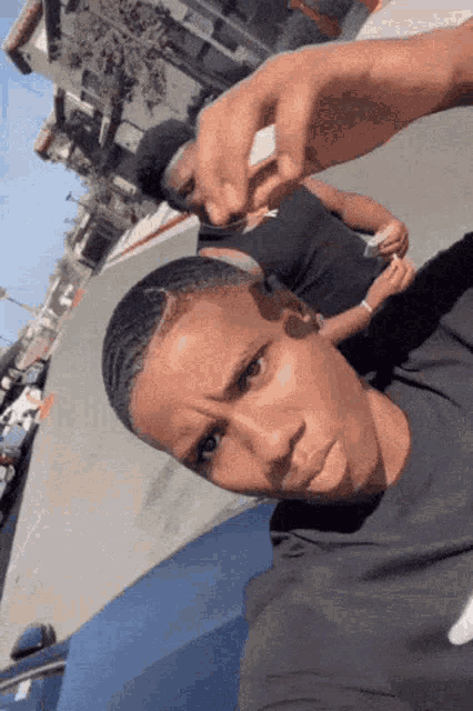 a man taking a picture of himself with another man behind him