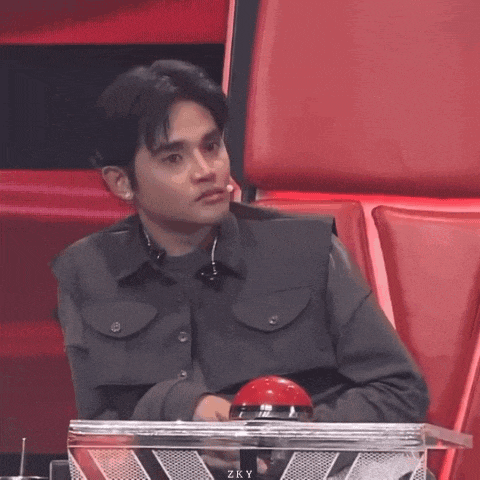 a man sits in a chair with a red button that says zky