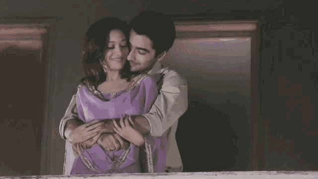 a man and a woman hugging on a balcony