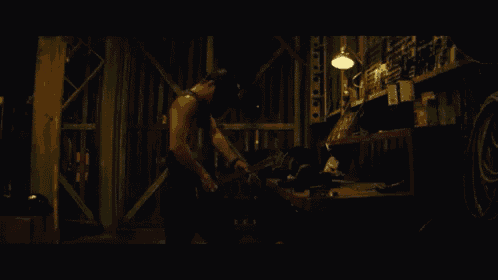 a man wearing a welding mask is cutting a piece of metal with a grinder