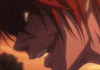 a close up of a person 's face with red hair making an angry face .