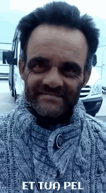 a man wearing a grey sweater with the words et tua pel written on the bottom